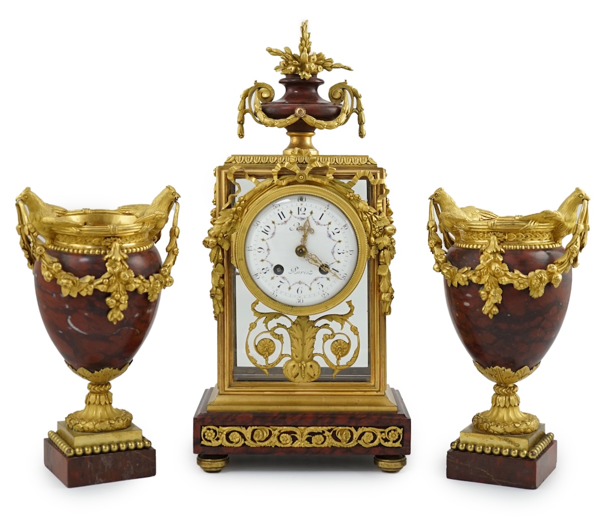 Revel à Paris. A 19th century French ormolu and rouge marble clock garniture